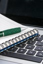 Notebook and pen on the laptop keyboard, close up Royalty Free Stock Photo