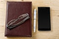 Notebook, pen and phone with blank screen on the table Royalty Free Stock Photo