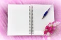 Notebook and pen on a pink background