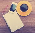 Notebook with pen, smart phone and coffee cup Royalty Free Stock Photo