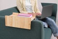 Notebook and pen on sofa armrest wooden table. Woman using laptop at home, closeup Royalty Free Stock Photo