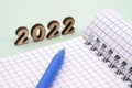 Notebook and pen on the table. A blank sheet of paper and a ballpoint pen. Wooden numbers 2022 Royalty Free Stock Photo