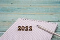 Notebook and pen on the table. A blank sheet of paper and a ballpoint pen. Wooden numbers 2022 Royalty Free Stock Photo