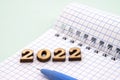 Notebook and pen on the table. A blank sheet of paper and a ballpoint pen. Wooden numbers 2022 Royalty Free Stock Photo