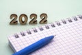 Notebook and pen on the table. A blank sheet of paper and a ballpoint pen. Wooden numbers 2022 Royalty Free Stock Photo