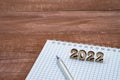 Notebook and pen on the table. A blank sheet of paper and a ballpoint pen. Wooden numbers 2022 Royalty Free Stock Photo