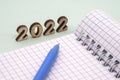 Notebook and pen on the table. A blank sheet of paper and a ballpoint pen. Wooden numbers 2022 Royalty Free Stock Photo