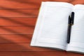 Notebook with pen on wooden table. Top view with copy space Royalty Free Stock Photo