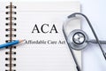 Notebook and pencil with ACA Affordable Care Act on the table wi