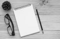 Notebook with pencil, glasses and pine cones on wooden table, Bl Royalty Free Stock Photo