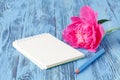 Notebook with a pencil and peonies flowers on the wooden background Royalty Free Stock Photo