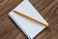 Notebook with pencil on wooden background