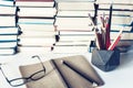 Notebook, pencils, glasses and stack of books, school background for education learning concept Royalty Free Stock Photo