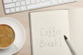 Notebook with phrase Coffee Break, cup of drink and keyboard on wooden table, flat lay Royalty Free Stock Photo