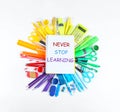 Notebook with phrase NEVER STOP LEARNING and school stationery on white background, top view