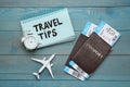 Notebook with phrase Travel Tips and tourist items on light blue wooden table, flat lay Royalty Free Stock Photo