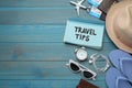 Notebook with phrase Travel Tips and tourist items on light blue wooden table, flat lay. Space for text Royalty Free Stock Photo