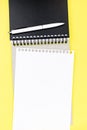 Notebook with piece of white clean squared paper on yellow table Royalty Free Stock Photo