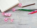 notebook pink flowers and pencil on wood background Royalty Free Stock Photo