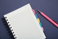 Notebook with pink pen on blue background Royalty Free Stock Photo