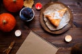 Notebook, pumpkin cheesecake, cooked at home, pumpkin, foliage, table lamp, vanilla on a wooden dark table. Autumn and Royalty Free Stock Photo