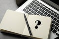 Notebook with question mark, pen and laptop on table, closeup Royalty Free Stock Photo