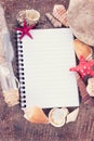 Notebook and seashells on wooden background Royalty Free Stock Photo