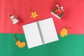 Notebook, snowman, santa claus and christmas or new year decoration and ornament on red and green background Royalty Free Stock Photo