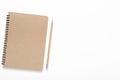 Notebook on a spiral of kraft paper with a pencil on a white background. Office desk, stationery. Copy space, top view, flat lay