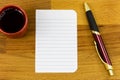 Notebook stationery lined note paper pen wooden background coffee cup Royalty Free Stock Photo