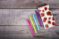 Notebook with strawberries and set of colored pens on wooden background Royalty Free Stock Photo