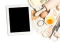 Notebook tablet pc and baking ingredients. foog background