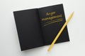 Notebook with text Anger Management and yellow pencil on white background, top view