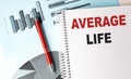 Notebook with text average life on white page with blue financial charts and red pen Royalty Free Stock Photo
