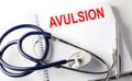 Notebook with text AVULSION with pen and stethoscope Royalty Free Stock Photo