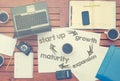 Notebook with text inside Start Up - cycle on table with coffee, some diagrams on paper and laptop Royalty Free Stock Photo