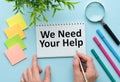 In the notebook the text we NEED YOUR HELP, next to the magnifying glass and pen Royalty Free Stock Photo