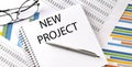 Notebook with text NEW PROJECT . Diagram and white background,Business concept Royalty Free Stock Photo