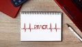 Notebook with text PEACE in the form of an ECG. Notebook on desk with laptop and a pen Royalty Free Stock Photo