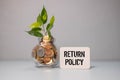 Notebook with text return policy on white desk with green leaves Royalty Free Stock Photo