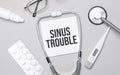 In the notebook is the text sinus trouble, stethoscope, pills, and glasses Royalty Free Stock Photo