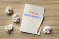 Notebook with text STRESS MANAGEMENT and crumpled paper balls on table, flat lay Royalty Free Stock Photo