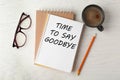 Notebook with text Time to say goodbye, office stationery and cup of coffee on white wooden table, flat lay Royalty Free Stock Photo