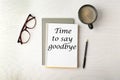 Notebook with text Time to say goodbye, office stationery and cup of coffee on white wooden table, flat lay Royalty Free Stock Photo