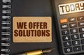 On the notebook there is a calculator with the inscription Today and a sign with the inscription - We Offer Solutions Royalty Free Stock Photo