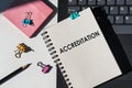 Notebook with tools and notes about ACCREDITATION lies on laptop