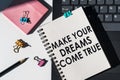 Notebook with tools and notes about MAKE YOUR DREAM COME TRUE lies on laptop