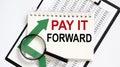 Notebook with Tools and Notes about PAY IT FORWARD with chart,business Royalty Free Stock Photo