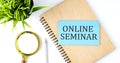 Notebook with Tools and Notes with text on the blue sticker ONLINE SEMINAR Royalty Free Stock Photo