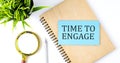 Notebook with Tools and Notes with text on the blue sticker TIME TO ENGAGE Royalty Free Stock Photo
